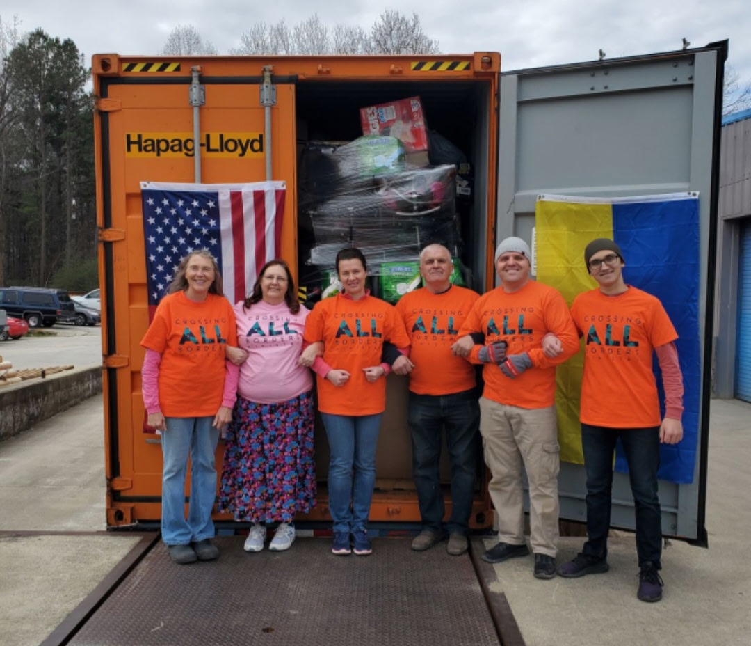 Picture of volunteers in front of shipping container